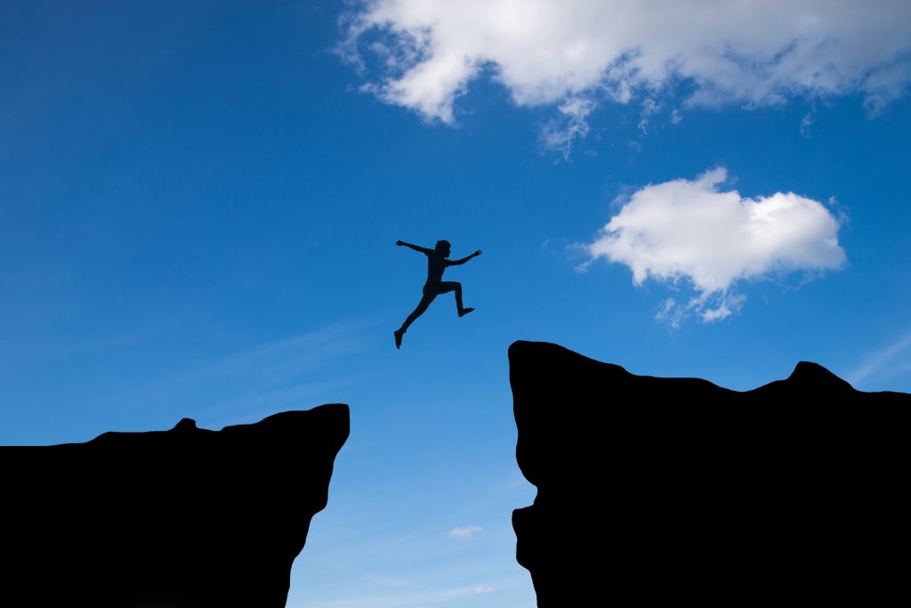 Man jump through the gap between hill
